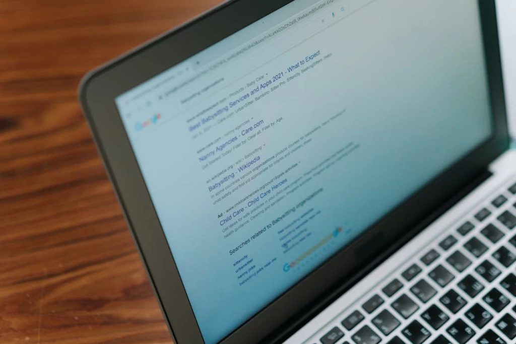 A laptop screen displaying Google search results for "babysitting services."